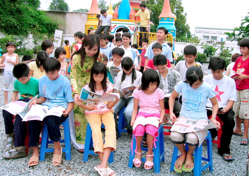 Mẹ Hương chỉ cho các con đọc thêm sách báo để tiếp thu thêm tri thức.